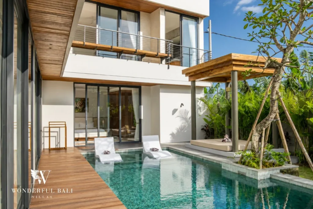 Infinity pool with two-storey villa exterior at villa in Umalas, Bali