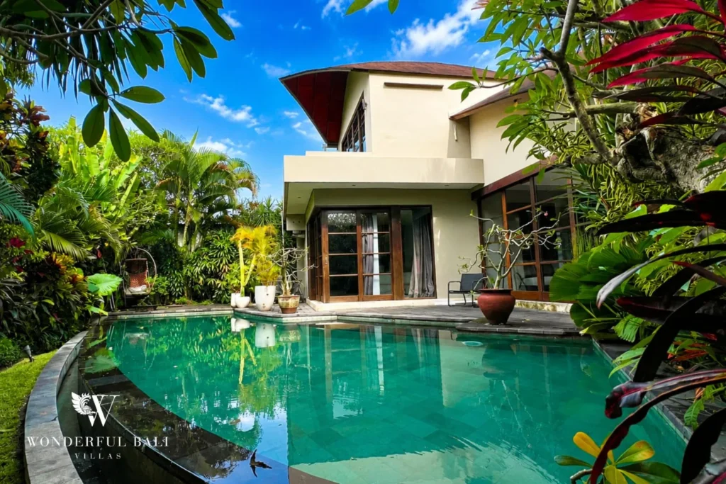Pool and villa exterior with tropical garden and palms at villa in Umalas, Bali