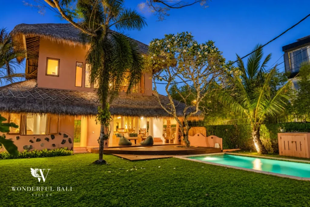 Pool and villa exterior with palms at dusk at villa in Bumbak, Bali