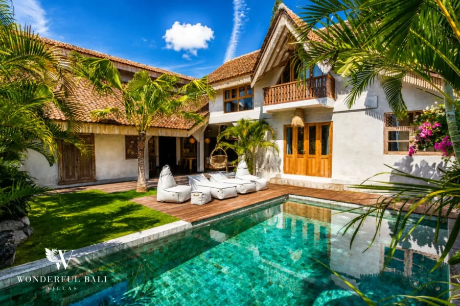 Pool and facade with alang-alang thatched roof at a villa in Canggu, Bali