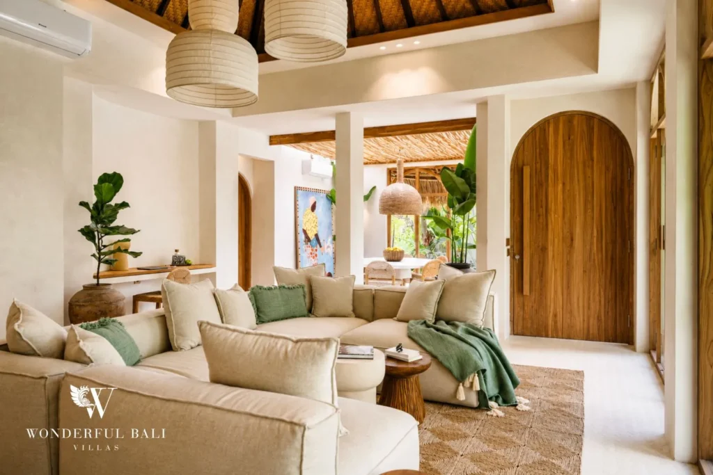 Living area with sofa and arched doorway in neutral tones at villa in Berawa, Bali