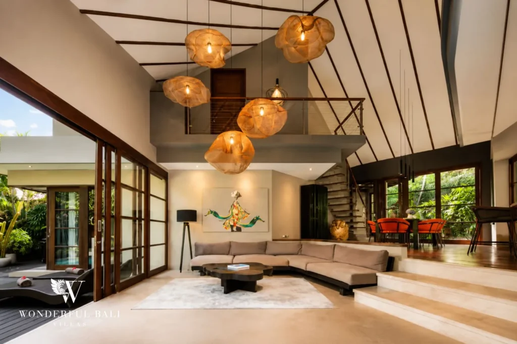 Open-plan living with sofa and woven globe pendant lights at villa in Umalas, Bali