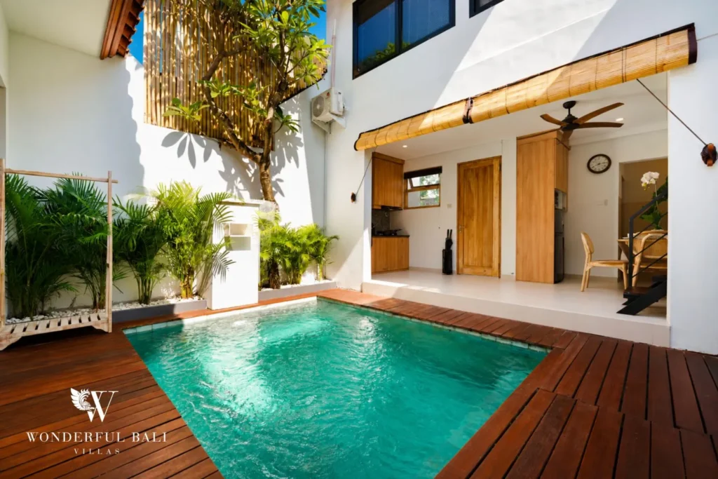 Courtyard pool with glass doors and open-air living beyond at villa in Canggu, Bali