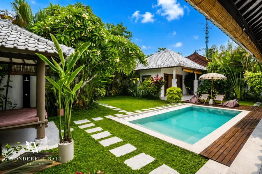 Private pool with tropical garden and sun loungers at villa in Umalas, Bali