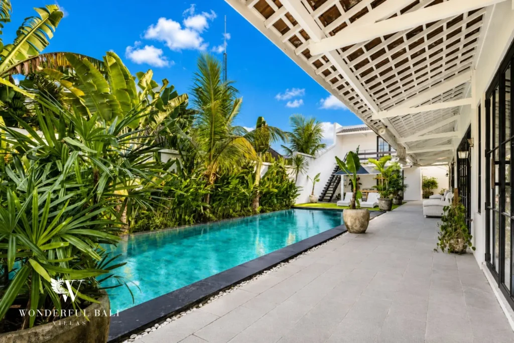 Pool with timber decking and glass doors to the villa at villa in Canggu, Bali