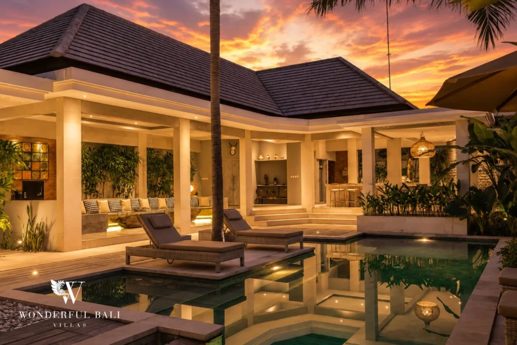 Pool at sunset with lit pavilions and reflective water at villa in Seminyak, Bali