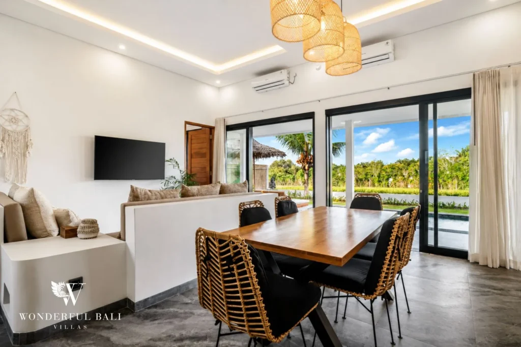 Dining area with pendant lights opening to the garden at villa in Ubud, Bali