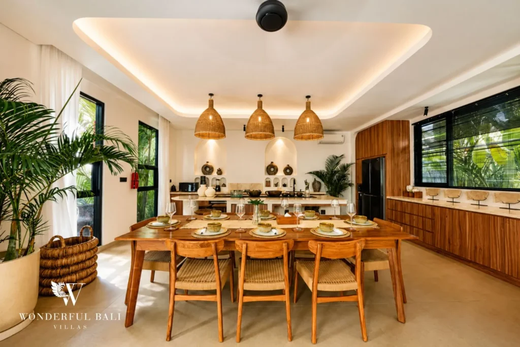 Dining area with woven pendants and open kitchen at villa in Umalas, Bali