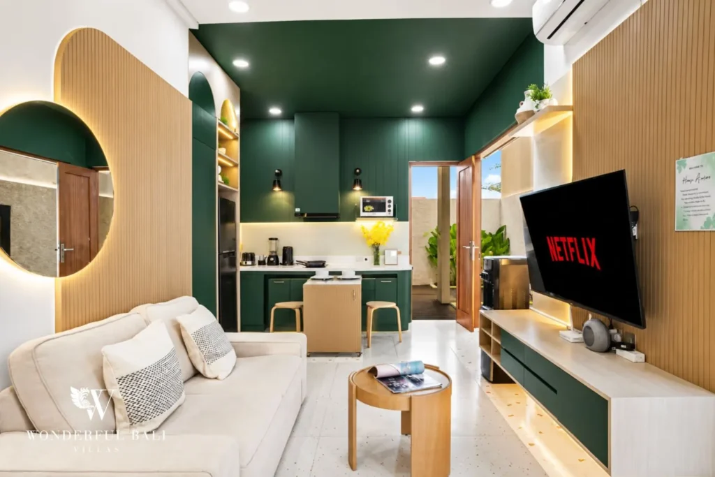 Living area with green feature wall, sofa and TV at villa in Denpasar, Bali