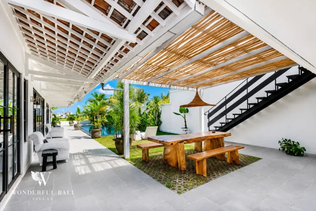 Outdoor dining under a bamboo pergola with pool view at villa in Canggu, Bali