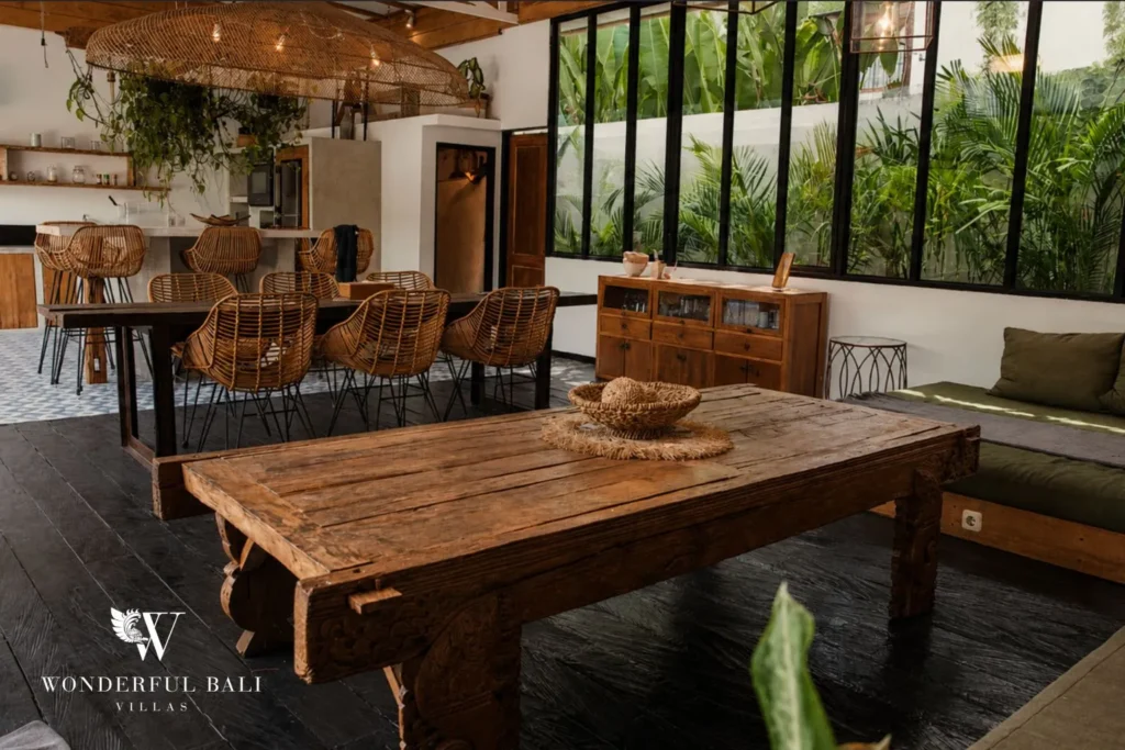 Dining table with glass walls and garden views at villa in Canggu, Bali