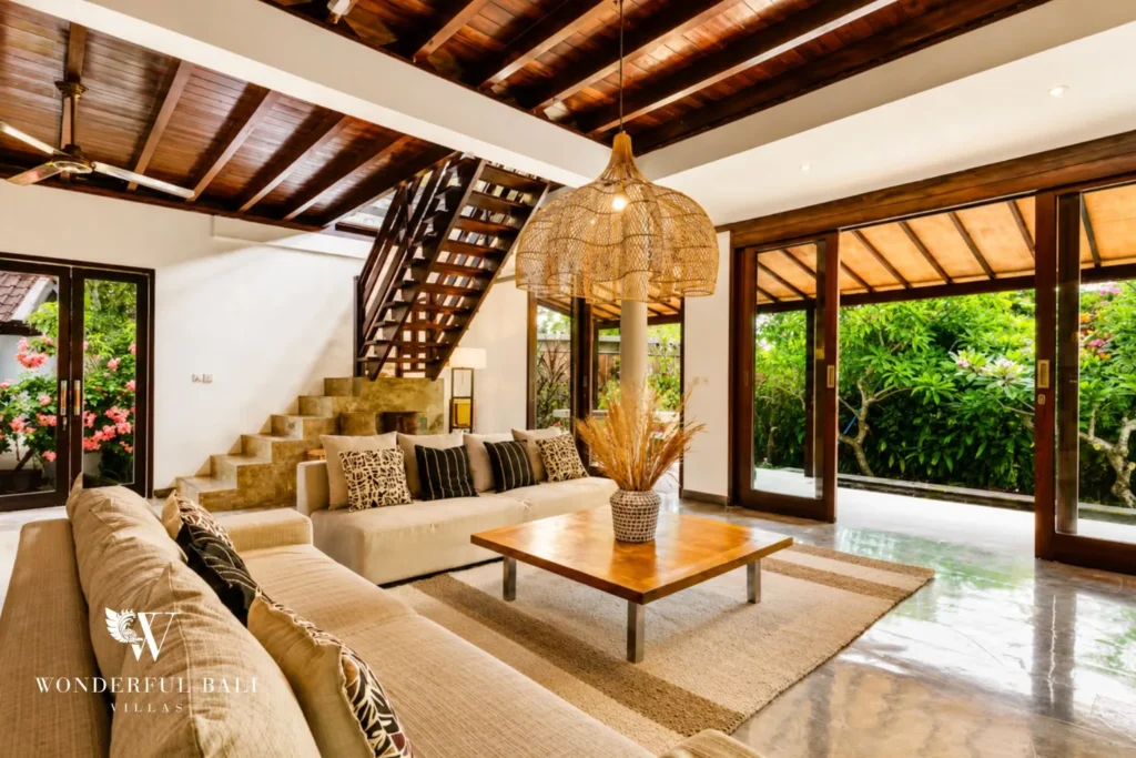 Living area with sofas and glass doors opening to the garden at villa in Umalas, Bali