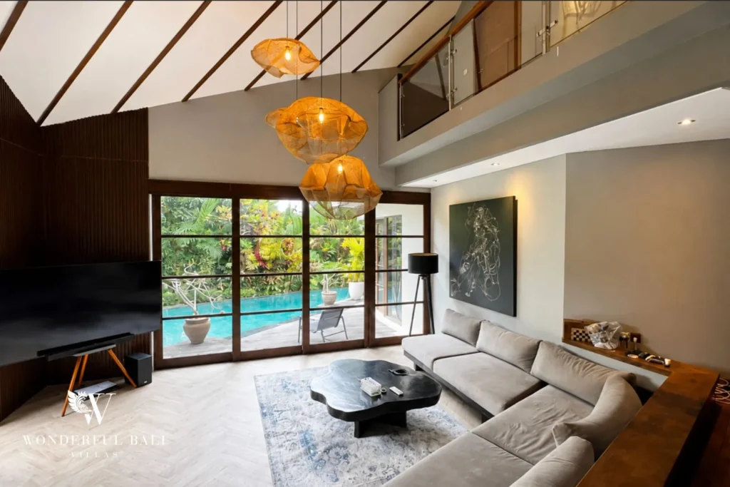 Living area with sofa and glass doors opening to the pool at villa in Umalas, Bali