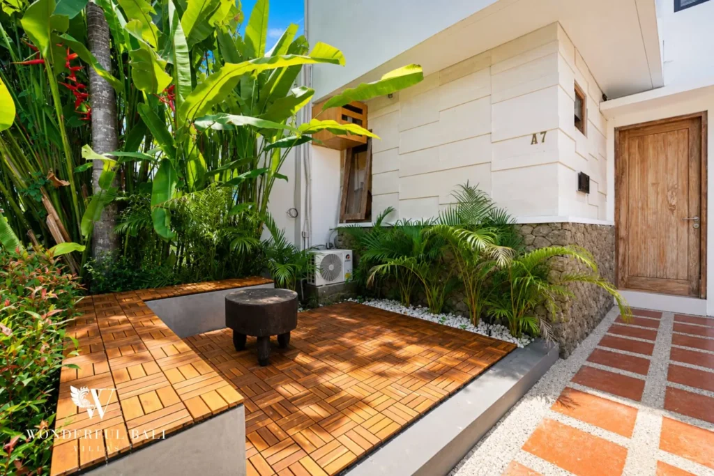 Living area with woven sun wall decor, rattan chairs and TV at villa in Canggu, Bali