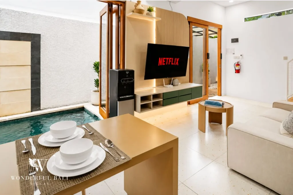 Living and dining with TV and glass doors to the courtyard at villa in Denpasar, Bali