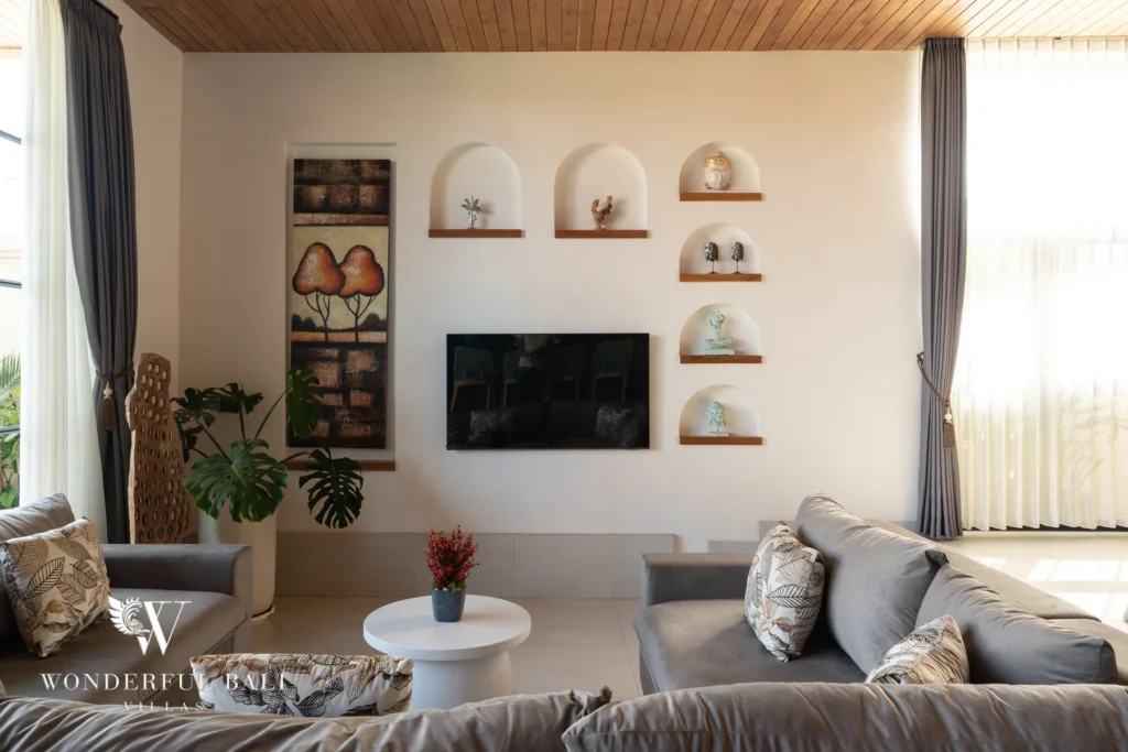 Living area with sofa, TV and arched wall niches at villa in Umalas, Bali