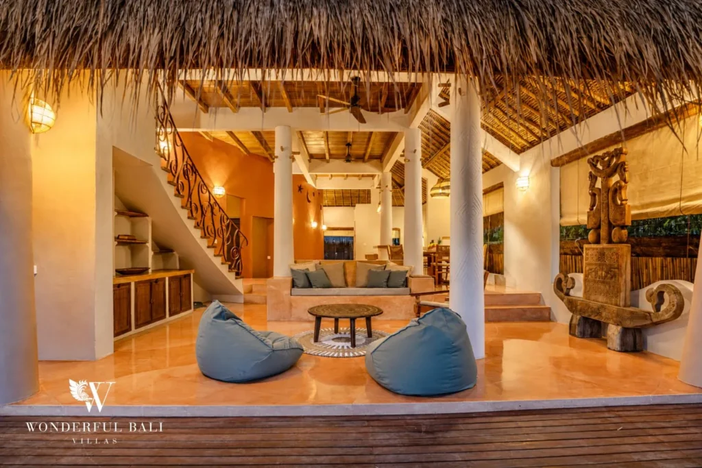 Open-air living pavilion with beanbags under a thatched roof at villa in Bumbak, Bali