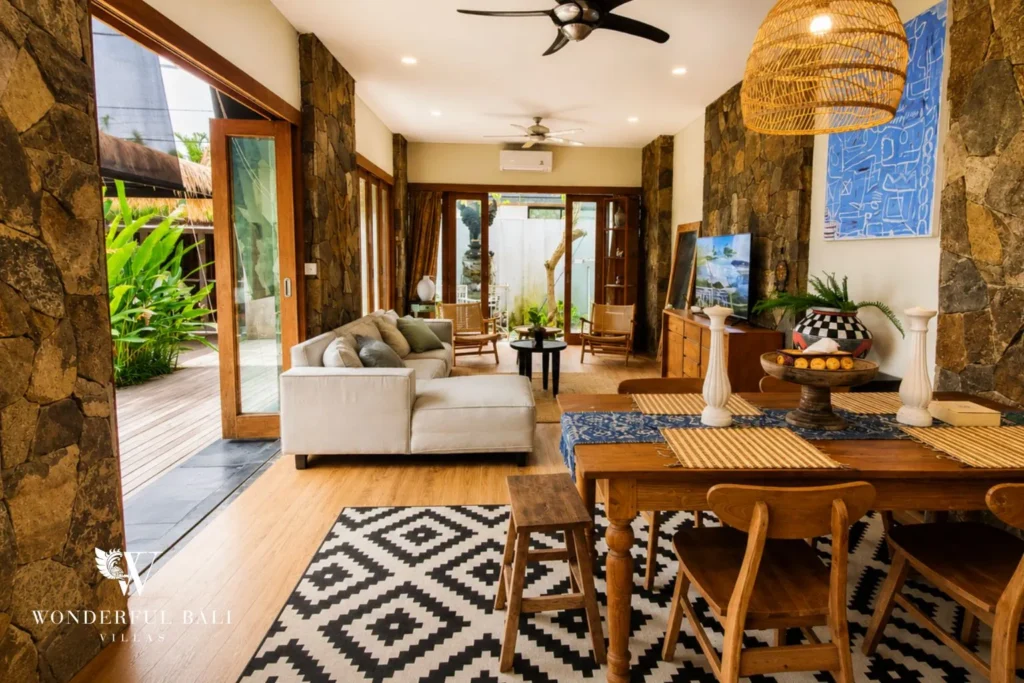 Open-plan living and dining with patterned rug and garden doors at villa in Berawa, Bali