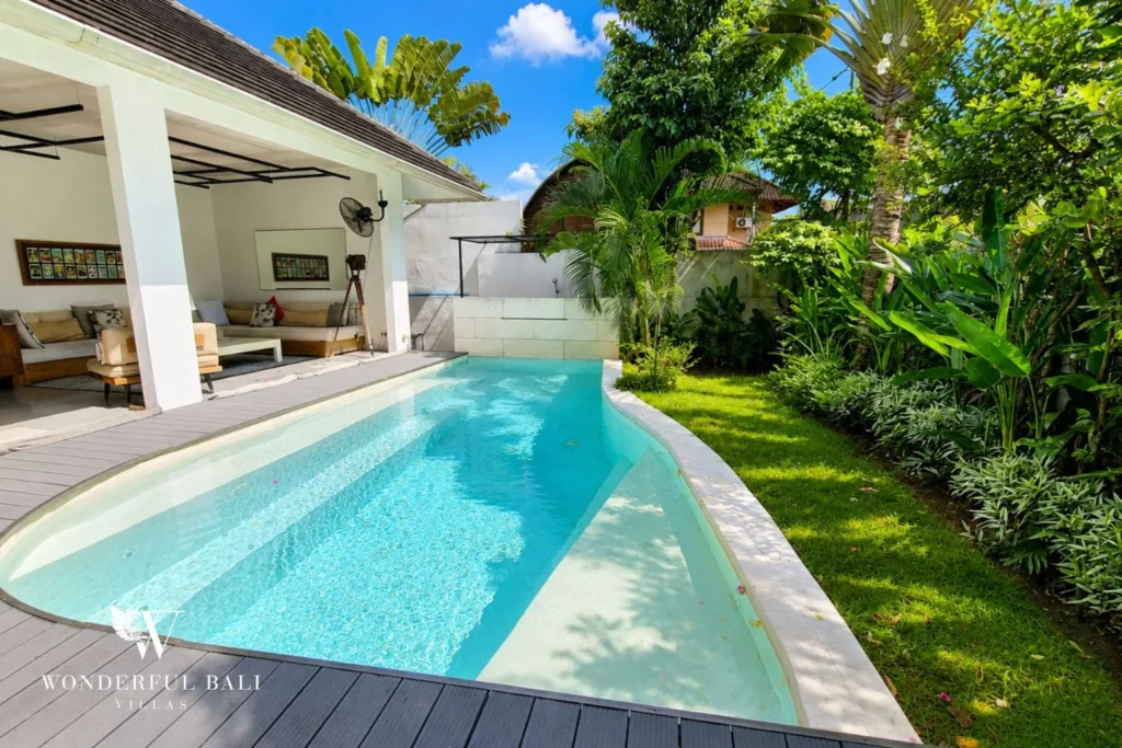Open-plan living and dining with industrial ceiling and pool view at villa in Umalas, Bali
