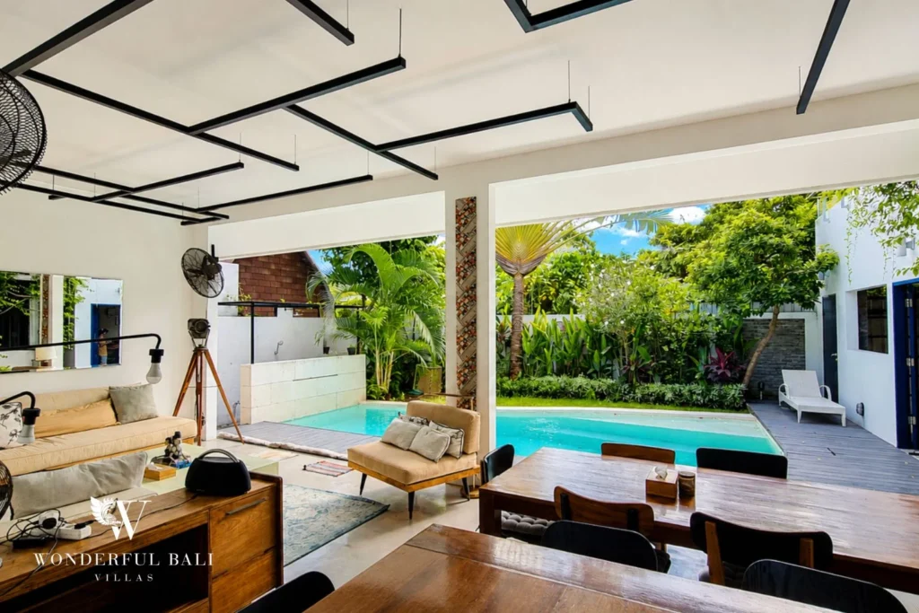 Industrial-ceiling lounge with daybeds and vintage tripod lamp at villa in Umalas, Bali