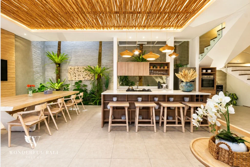 Modern kitchen with island and large dining table at villa in Petitenget, Bali