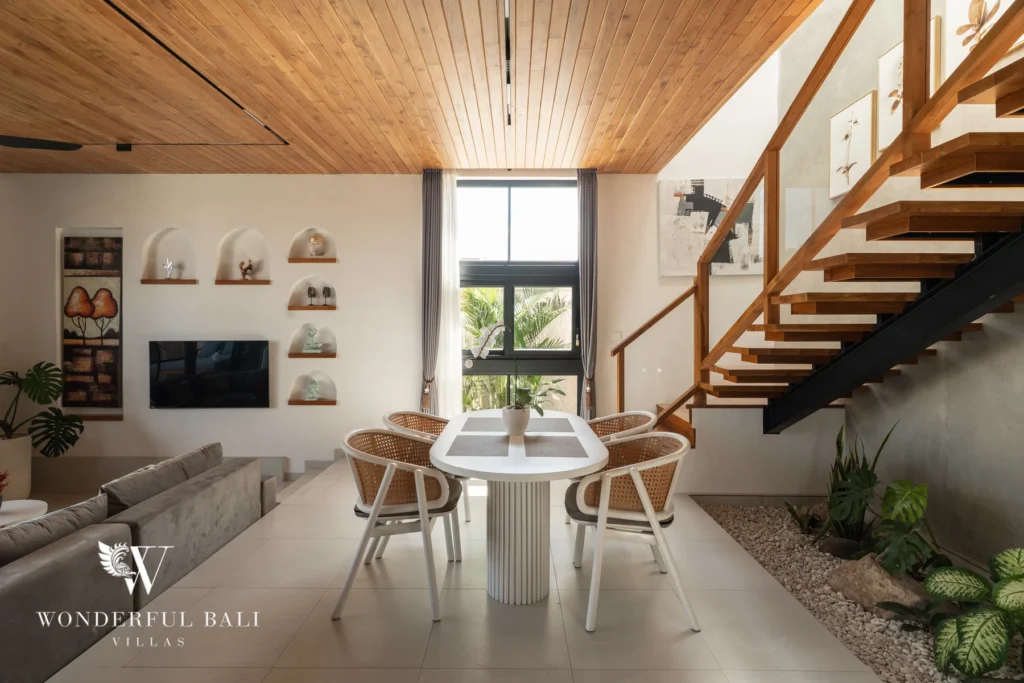 Living and dining area beside a timber staircase at villa in Umalas, Bali