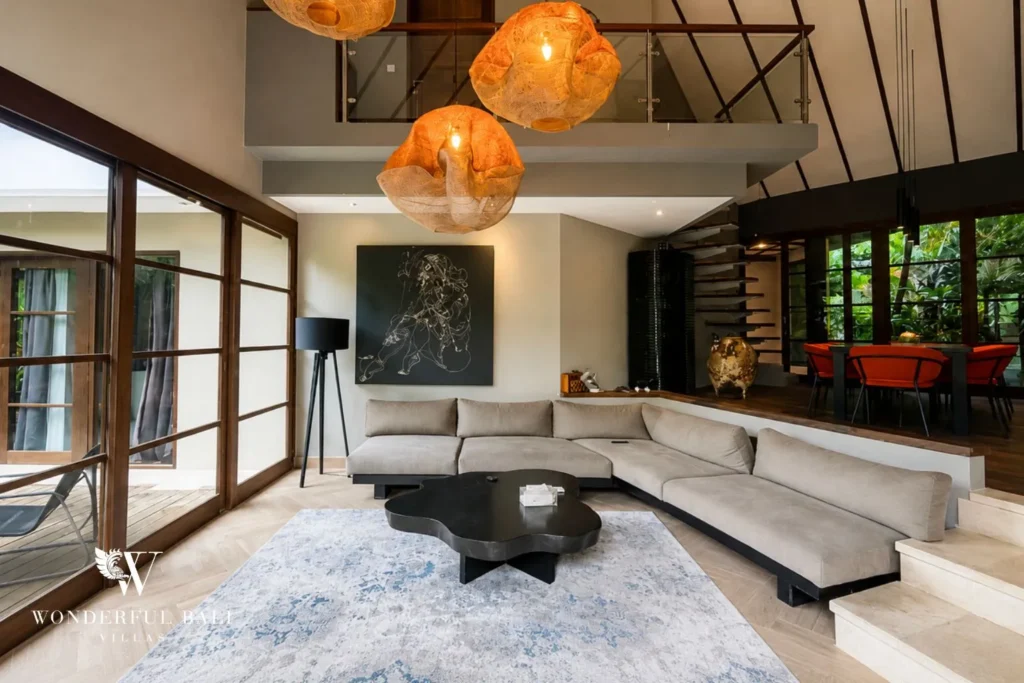 Living lounge with grey sectional sofa under a high pitched ceiling at villa in Umalas, Bali