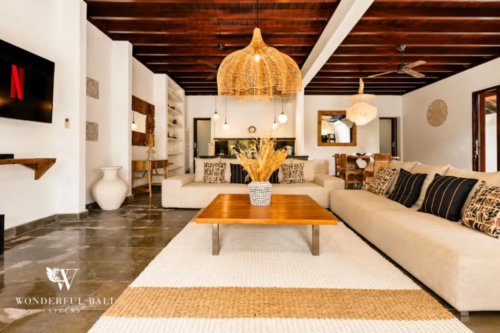 Living lounge with sofas, TV and warm pitched timber ceiling at villa in Umalas, Bali
