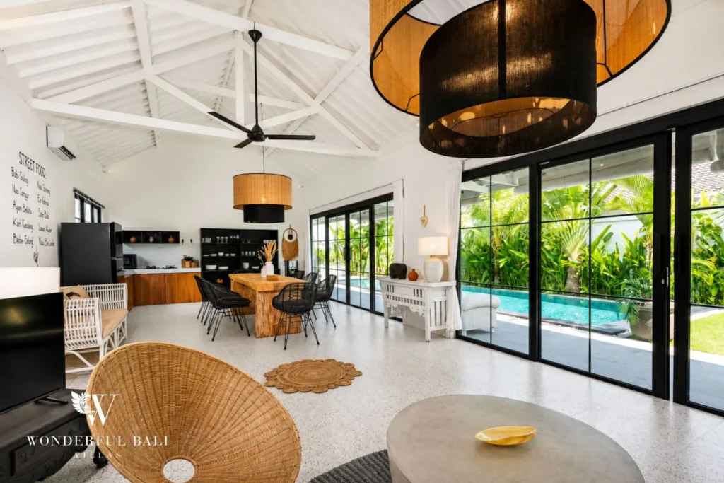 Open living area with sofa and glass doors to the pool at villa in Canggu, Bali
