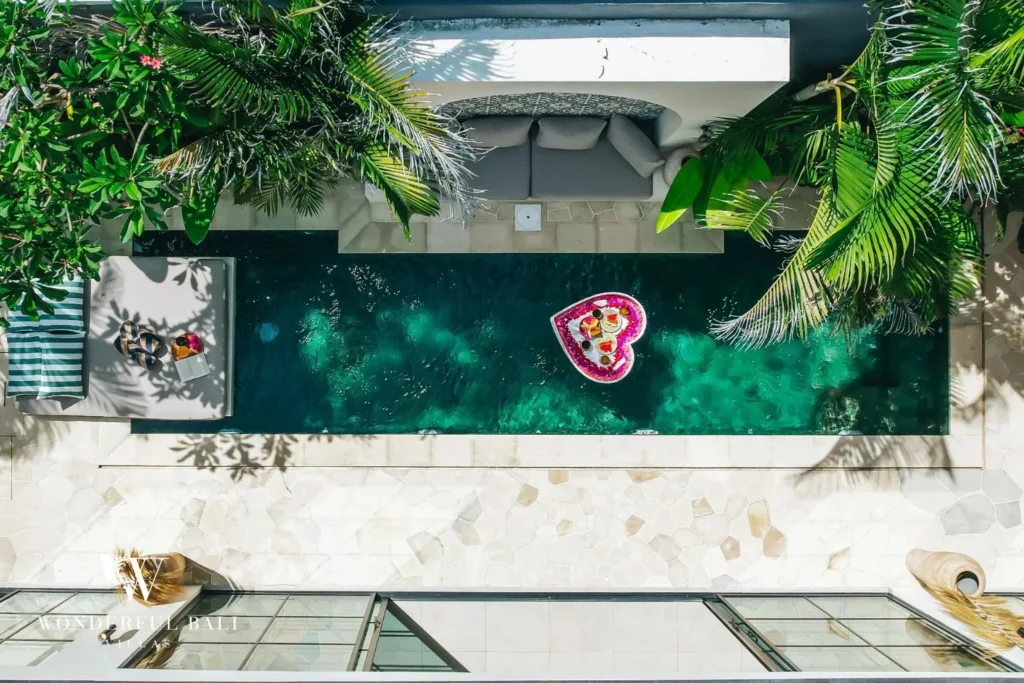 Plunge pool with sun lounger and tropical garden at villa in Seseh, Bali