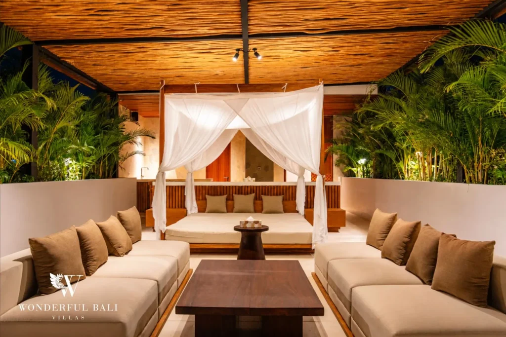 Bedroom with canopy bed and lounge open to the garden at villa in Umalas, Bali
