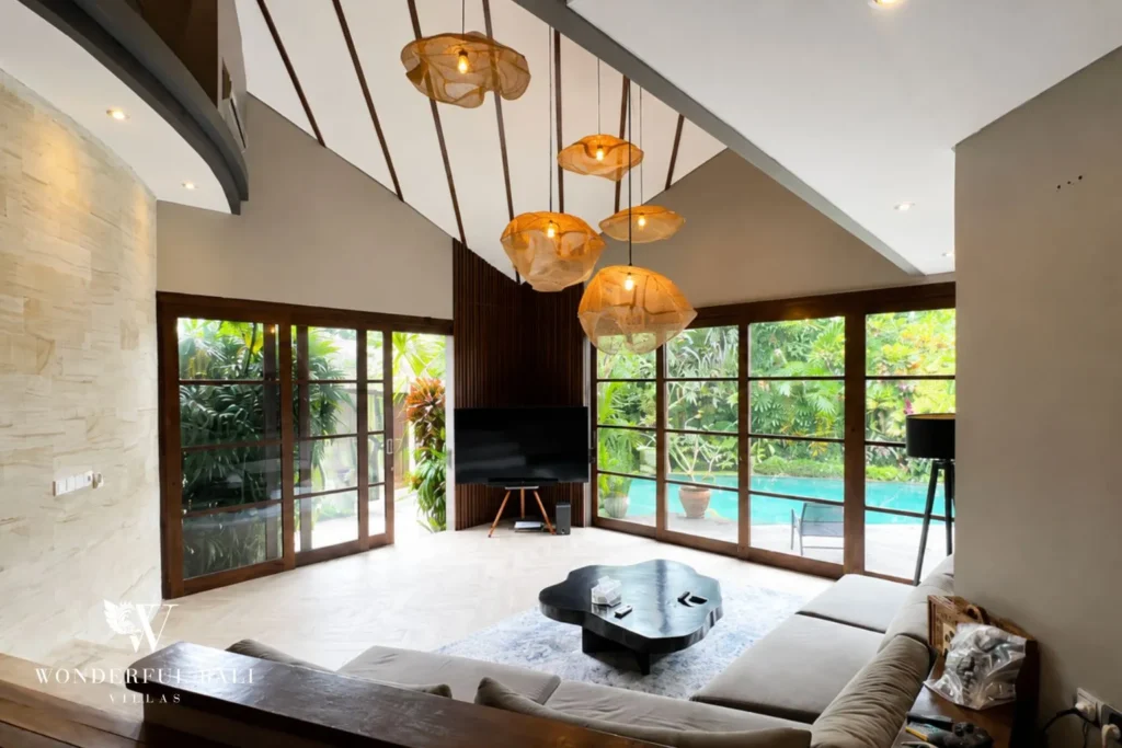 Dining area with pendant lights and glass doors to the pool at villa in Umalas, Bali