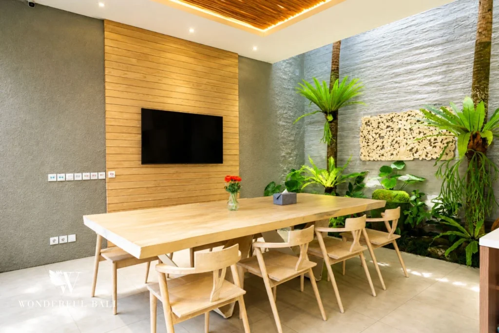 Dining area with TV opening to the pool at villa in Petitenget, Bali