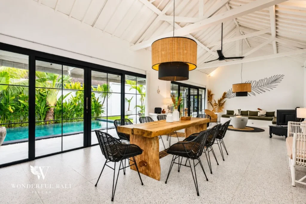 Dining table with black chairs and woven pendants at villa in Canggu, Bali