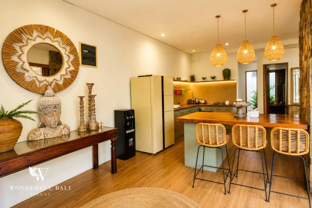 Kitchen and dining with round mirror, bar stools and pendant lights at villa in Berawa, Bali