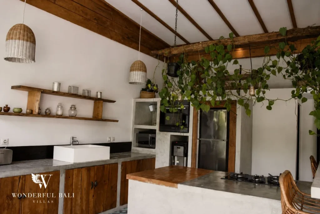 White kitchen with open shelving and potted plants at villa in Canggu, Bali