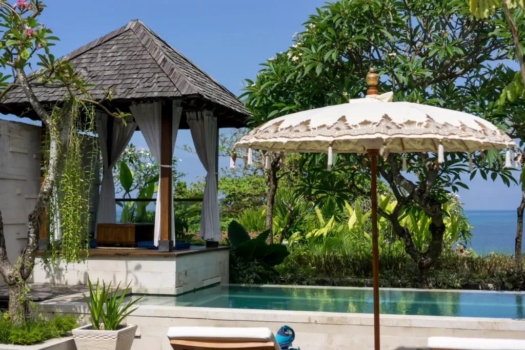 Poolside bale with umbrella and sun loungers at villa in Batu Belig, Bali