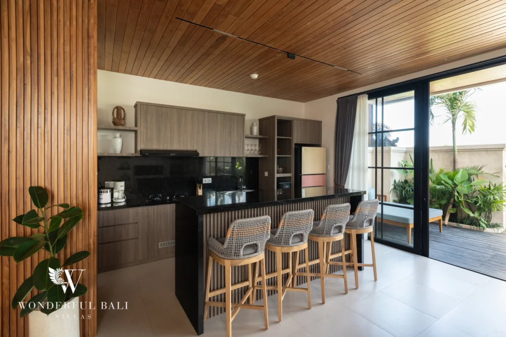 Kitchen with bar stools and glass doors to the garden at villa in Umalas, Bali