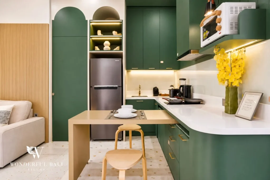 Kitchen with green cabinets and arched niche shelving at villa in Denpasar, Bali