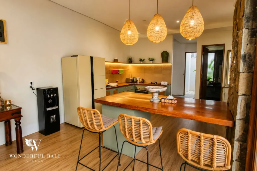 Kitchen island with bar stools and woven pendant lights at villa in Berawa, Bali