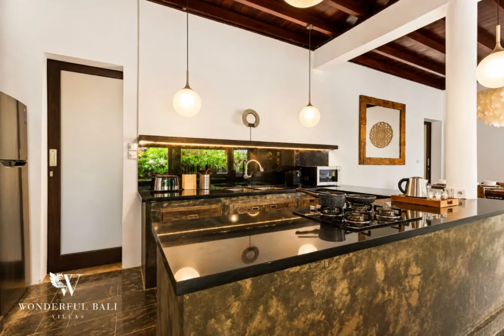 Kitchen island with stove and pendant lights in open-plan space at villa in Umalas, Bali