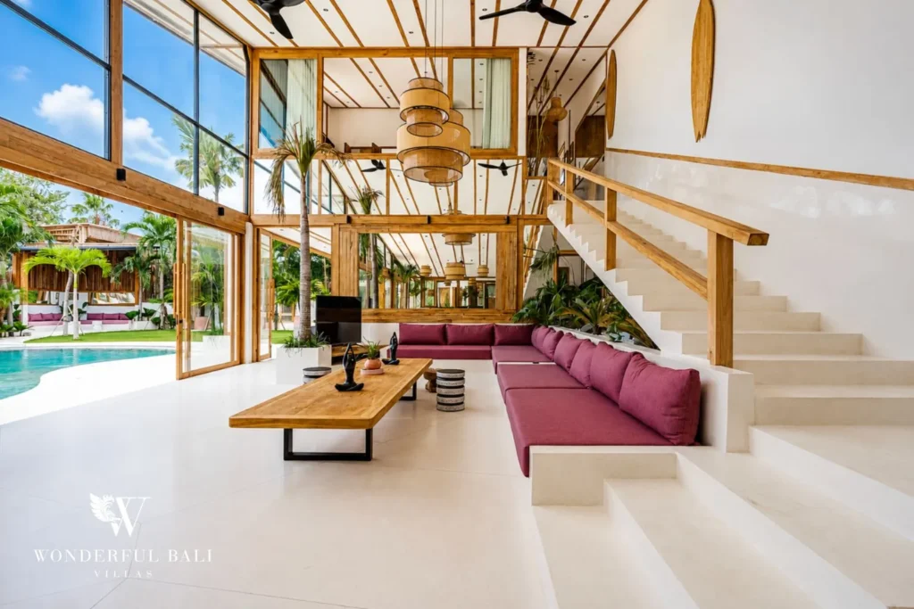 Living area with floor-to-ceiling glass walls and pool view at family villa in Umalas, Bali