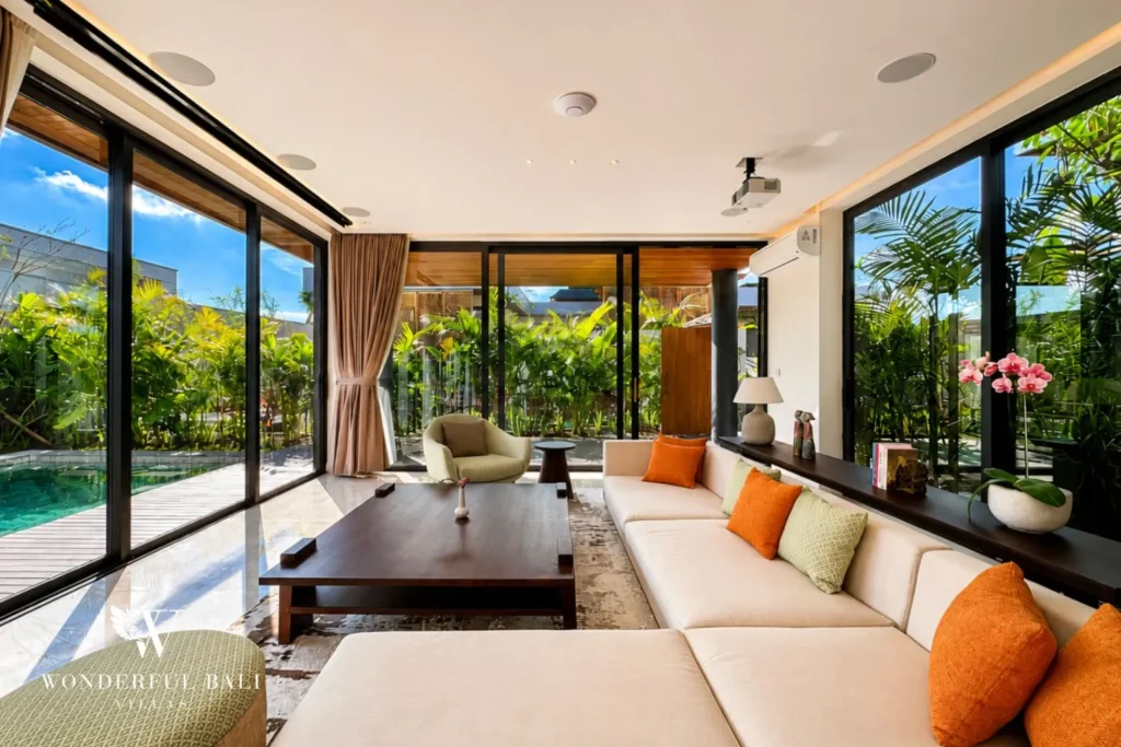 Living area with sofas and floor-to-ceiling glass walls at villa in Umalas, Bali