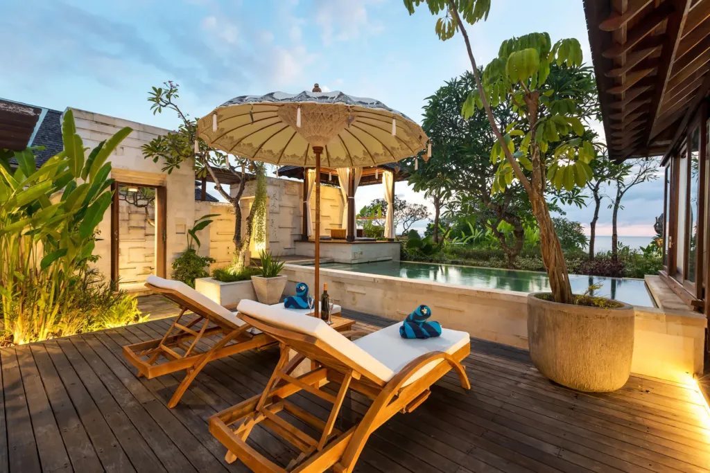 Pool with sun loungers in the evening light at villa in Batu Belig, Bali