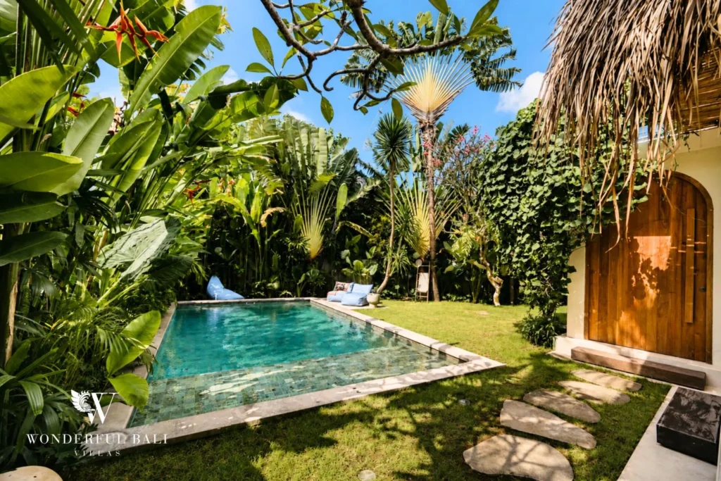 Pool with stepping stones and arched doors to the garden at villa in Berawa, Bali