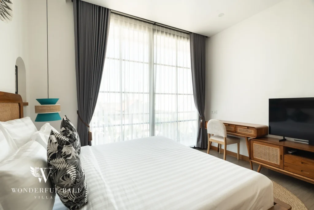 Bedroom with TV, timber console and curtains at villa in Umalas, Bali