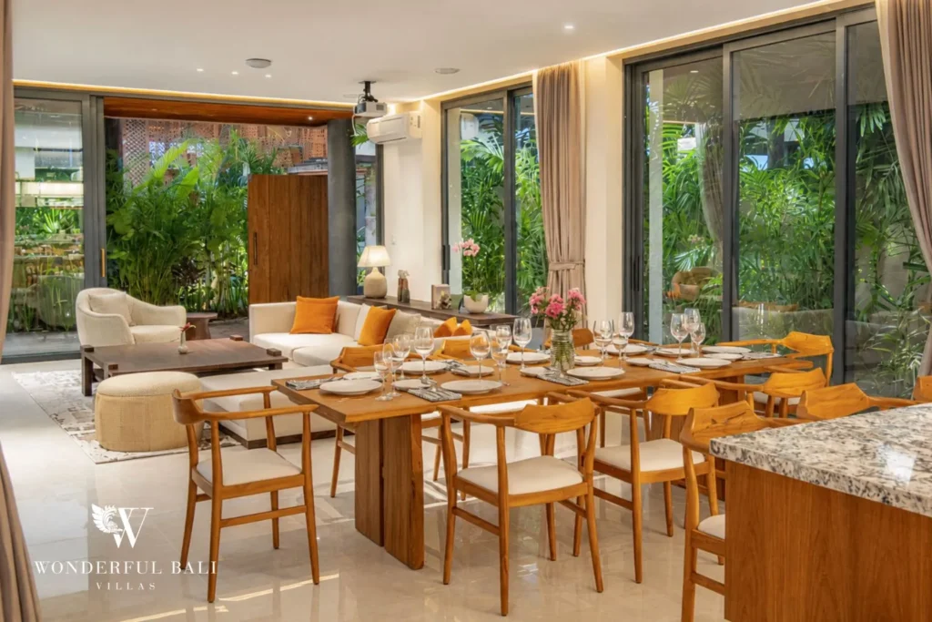 Dining table with garden view and glass walls at villa in Umalas, Bali