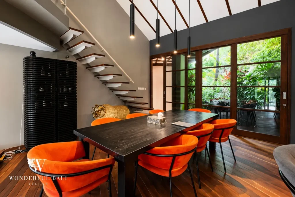 Dining table with orange chairs and pendant light at villa in Umalas, Bali