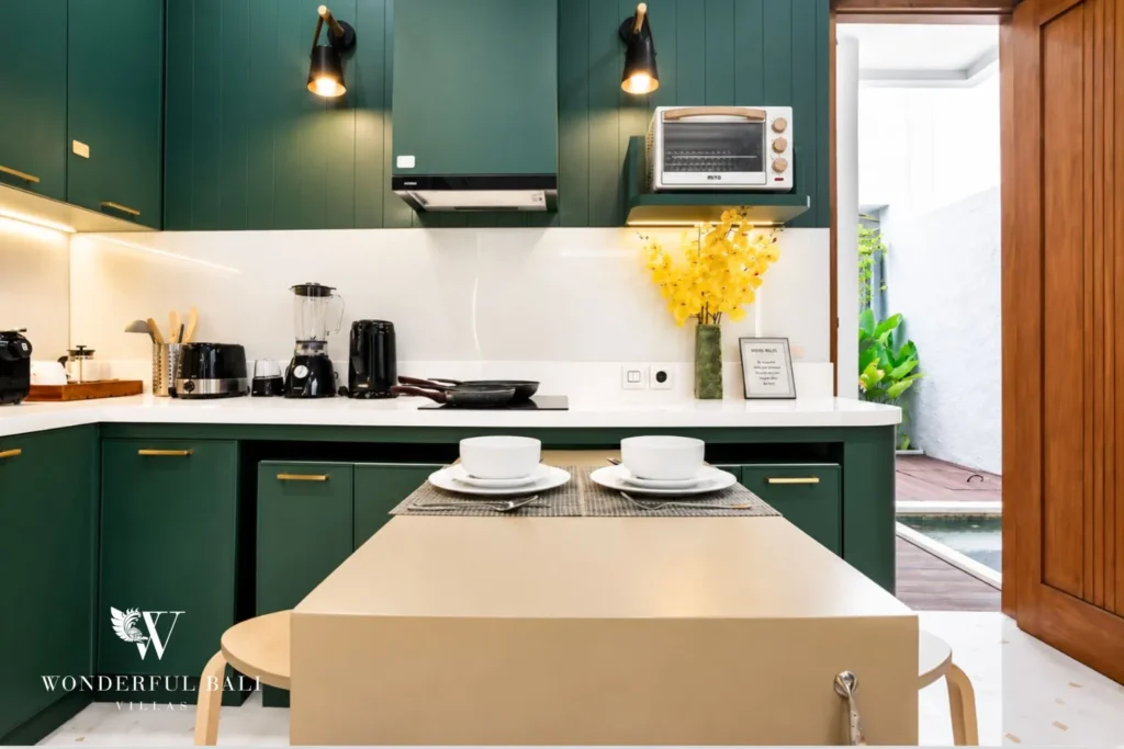 Kitchen with green cabinets, island and bar stools at villa in Denpasar, Bali