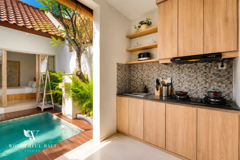 Kitchen with timber cabinets and natural stone backsplash at villa in Canggu, Bali